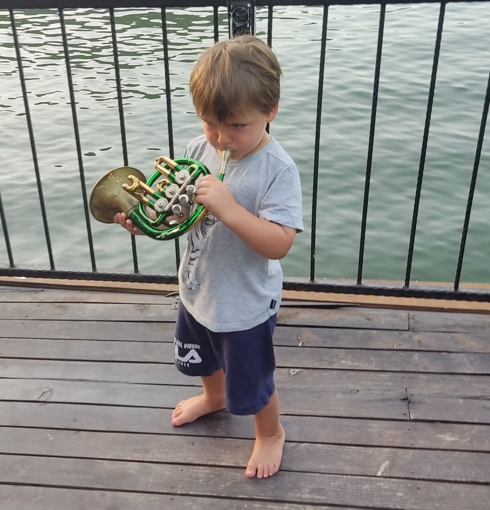 Ein kleiner Junge spielt Horn